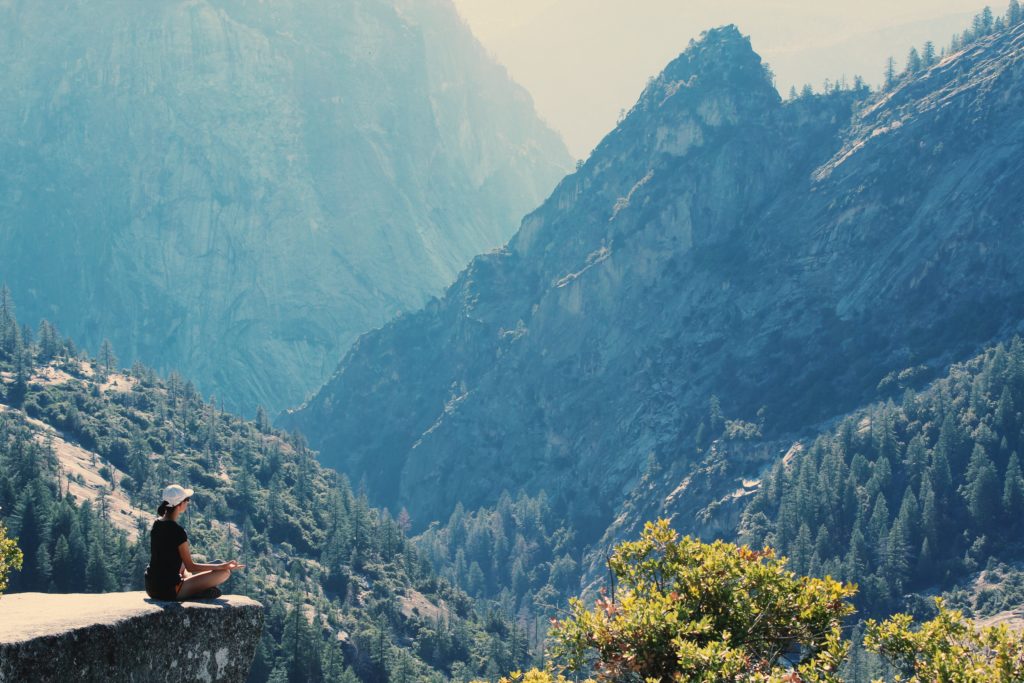 Une joggeuse pratiquant la méditation de concentration en face d'une montagne.